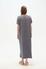 Vestido midi negro de poliéster, corte holgado, manga corta, cuello en V y detalle de cuentas en el escote.