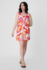Vestido corto sin mangas con estampado de hojas en tonos rosa, naranja y blanco.