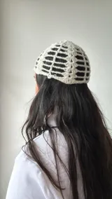 Gorro de crochet color crudo, con diseño calado y lentejuelas.