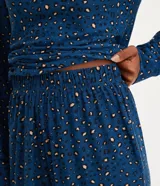 Conjunto de pijama femenino de poliéster y elastano, compuesto por una remera de manga larga con cuello en V y un pantalón largo con puños ajustados. Estampado animal print de jaguar.