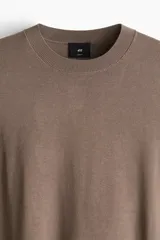 Remera marrón de punto fino, con cuello redondo y mangas cortas.