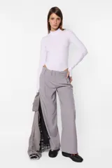 Body blanco de algodón con lycra, de manga larga con detalle de mitón en los puños y cuello media polera.