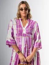 Vestido midi de corte amplio con estampado abstracto en tonos azules, blancos y beige. Tiene cuello en V, mangas 3/4 con volados y corte escalonado en la falda.