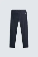 Pantalón chino color beige, corte skinny fit, confeccionado en tejido con mezcla de algodón y elasticidad. Cuenta con bolsillos frontales y traseros. Cierre frontal con cremallera y botón.
