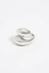 Anillo plateado de metal con diseño en espiral y logo grabado.