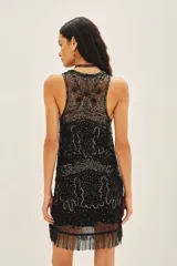Vestido corto negro de tul bordado con piedras, lentejuelas, canutillos y flecos de mostacillas. Tiene escote redondo, calce recto y viso a tono con breteles finitos.