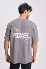 Camiseta manga corta oversize color gris oscuro con estampa trasera con la palabra 'Pixel' en blanco y diseño geométrico.