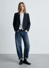 Blazer negro con raya diplomática, cuello de pico con solapa, cierre de botones en la parte delantera, manga larga con puños abotonados, diseño recto y estructurado, un bolsillo de ribete en el pecho y dos bolsillos de ribete con solapa laterales.