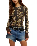 Blusa térmica de waffle con estampado floral, cuello redondo con pespuntes en contraste, mangas largas con puños marrones y dobladillo sin rematar.