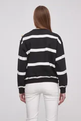 Sweater rojo con rayas horizontales blancas y botones dorados en los hombros.