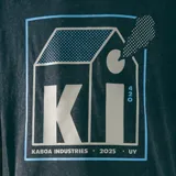 Remera negra de corte oversize con efecto lavado y estampado frontal con un diseño gráfico que incluye un logo con las letras 'KI', un dibujo de una casa y el número '420'.