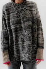Buzo de punto con diseño de rayas en tonos morados y beige, de corte holgado y mangas largas.
