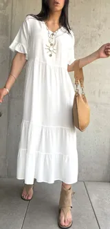 Vestido midi blanco con corte en capas, mangas cortas con volados y cuello redondo.