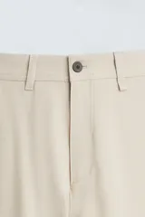 Pantalón de vestir gris oscuro, corte slim fit, con bolsillos laterales y traseros con botón.