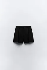 Bermudas negras de tiro alto con bolsillos delanteros, pinzas delanteras y cierre frontal con cremallera y ganchos metálicos.