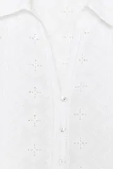 Camisa corta blanca con bordados perforados, cuello solapa, escote pico y manga larga abullonada.