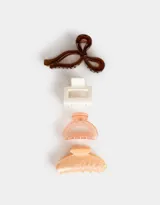 Set de cuatro broches para el pelo de diferentes formas y colores: marrón con forma de moño, blanco rectangular, salmón con forma de media luna y naranja con efecto marmolado y forma de media luna.