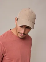 Gorro con visera color beige confeccionado en lona de algodón con logo bordado en el frente.