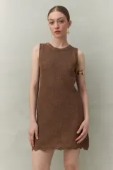 Vestido de tejido con trama abierta y caída liviana, confeccionado en un hilado con acabado metalizado. Silueta recta y sin mangas.