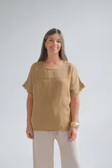 Remera color tostado de lino italiano, con escote a la base, corte amplio y mangas cortas con detalle de flecos.