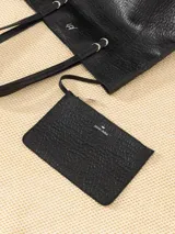 Bolso tipo tote negro de cuero vacuno con textura granulada, doble asa de hombro, apliques color marfil y logo JCH plateado en el frente. Incluye sobre desmontable en el interior.