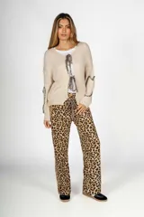 Saco largo color beige de tejido de punto con detalle de lazos con estampado animal print en el frente y en las mangas.