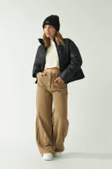 Campera corta color crema con cuello alto y cierre frontal con botones a presión.