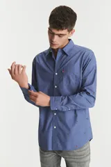 Camisa de manga larga azul con estampado de ciervos en color marrón. Tiene un bolsillo en el pecho y cierre con botones.