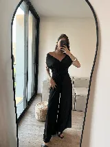 Mono negro con escote off-shoulder, mangas cortas y corte a la cintura con nudo.