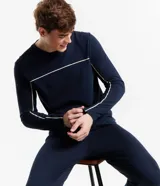 Pijama largo de algodón azul marino para hombre, compuesto por remera de manga larga con cuello redondo y pantalón con cintura elástica y lazo ajustable. Presenta detalle de bies contrastante en color crema en cuello, puños y laterales del pantalón.