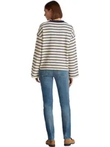 Jean de mezclilla elástica de algodón, color azul medio con efecto desteñido y arrugado. Presenta un corte ajustado y cintura media, con cierre de cremallera y botón, y estilo de cinco bolsillos.