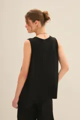 Musculosa blanca de algodón con cuello redondo y sisas amplias.