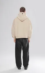 Hoodie beige de frisa premium con bolsillo canguro y calce oversize cropped.