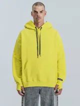 Hoodie amarillo neón de frisa premium con capucha ajustable, corte oversize, cintura y puños elastizados.