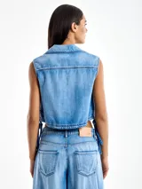 Chaleco crop top de denim celeste, con escote en V, cuello con solapa y cordones laterales ajustables.