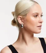 Par de aros pequeños de metal plateado con forma de gota.