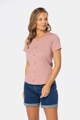 Remera blanca de tejido rib, con cuello redondo y botones fijos. Es de manga corta y está confeccionada en algodón y elastano.