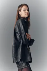 Camisa de cuero ovino negro con efecto arrugado, de moldería amplia, con cuello camisero y botones a presión con logo.