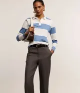 Pantalón de vestir gris claro, de corte recto, con bolsillos laterales y traseros. Se ajusta a la cintura con cinturón de cuero negro.