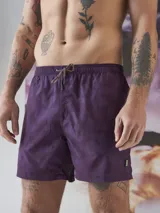 Short de baño color borgoña con estampado de hojas en tono sobre tono, cintura elástica con cordón ajustable y logo de la marca en la pierna.