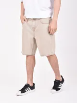 Bermuda de jean color beige, corte recto y largo a la rodilla.