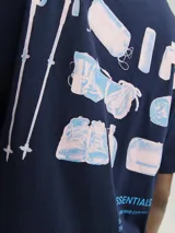 Camiseta azul marino de manga corta y cuello redondo con estampado en la espalda de elementos de camping y la frase "HIKE ESSENTIALS ESCAPE INTO NATURE AND EXPLORE THE UNKNOWN".