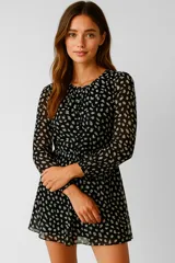 Vestido corto negro con estampado de manchas blancas, cuello redondo y mangas largas.