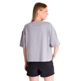 Remera gris de corte amplio con mangas cortas y ruedo recto. Presenta un pequeño estampado con el logo de Caterpillar y una flor en el lado izquierdo del pecho.