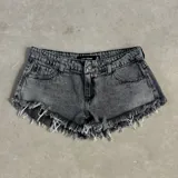 Short de jean gris oscuro con efecto lavado, tiro alto, corte ajustado y flecos en el ruedo.