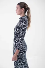 Vestido midi con estampado cebra, corte al cuerpo, cuello camisero y abotonadura frontal.