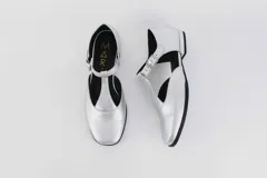 Zapato flat de cuero con estampado de vaca en blanco y negro, con tira delantera y hebilla lateral.