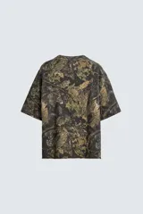 Sudadera relaxed fit con estampado de hojas en tonos verde, marrón y negro. Tiene cuello redondo, manga corta y bajo irregular con aberturas laterales.