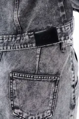 Minifalda de jean gris con efecto lavado, tiro alto y corte ajustado.