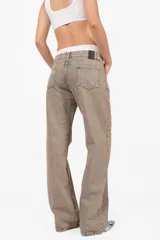 Pantalón de denim corte recto, tiro medio, color arena. Acceso con cierre metálico y botón personalizado. Cintura con cinco presillas, logo estampado en la parte trasera y bolsillos laterales con remaches. Lavado artesanal con matizado color arena. Los tonos pueden variar.